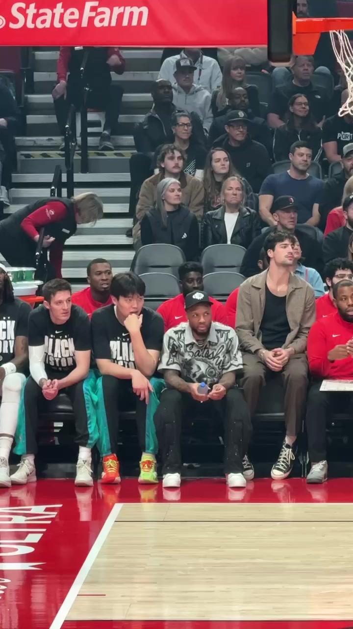 开云APP-静静等待机会！小吧拍到杨瀚森坐在利拉德旁 认真观察场上局势